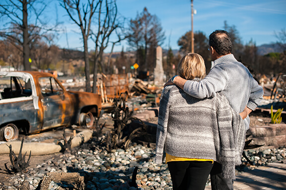 Adult couple seeing damage after wildfire disaster